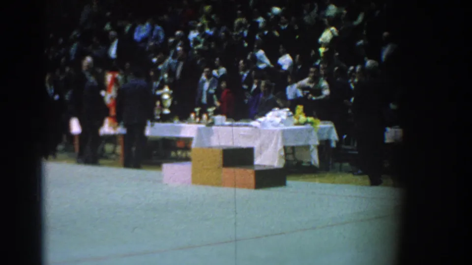 1966 San Gabriel martial arts ceremony scene with spectators, a white awards table, trophies, and officials or competitors near the mat.