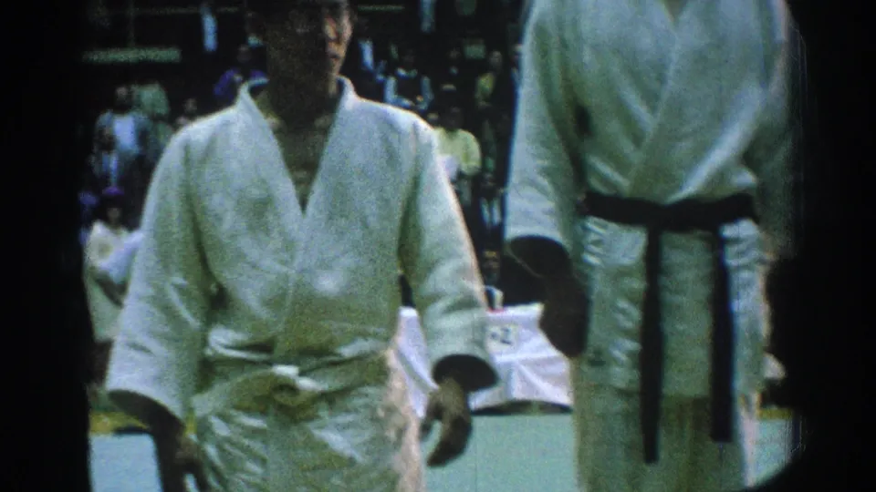 1966 San Gabriel frame with martial arts competitors in white gi and belts standing close to the camera on the mat.