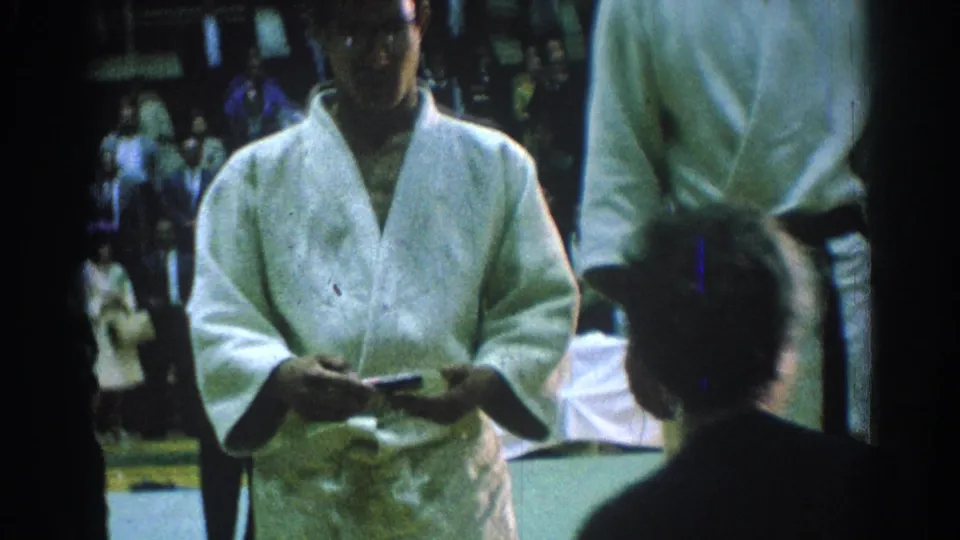 A young karate competitor in a white gi appears to hold a medal or award during the 1966 San Gabriel ceremony.