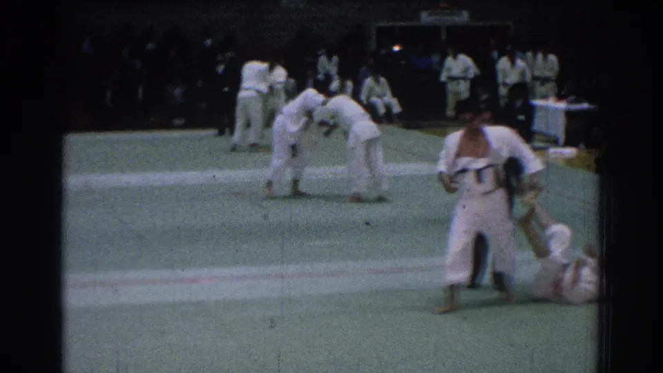 1966 San Gabriel martial arts competition footage showing men in white gi uniforms grappling on a green gym mat.