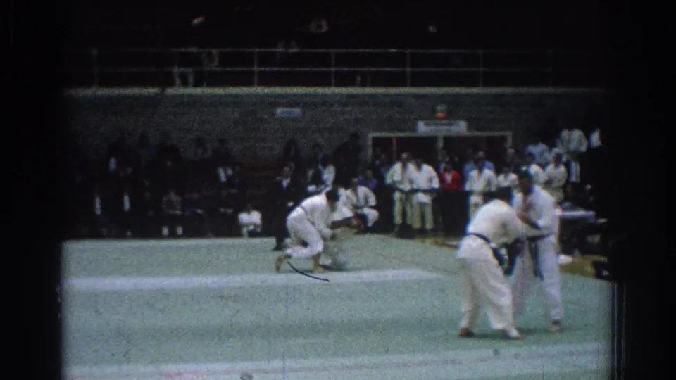 1966 San Gabriel martial arts competition showing standing competitors on a green mat before a throw or grip exchange.