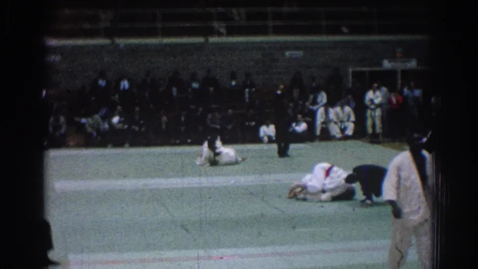 A 1966 San Gabriel judo bout shows two competitors on the green mat, with a referee and spectators visible in the background.