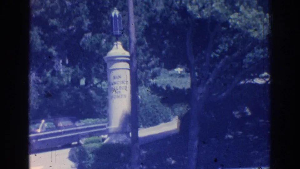 Closer 1966 San Gabriel park view with a stone monument or marker, surrounding trees, and a partially visible roadway.
