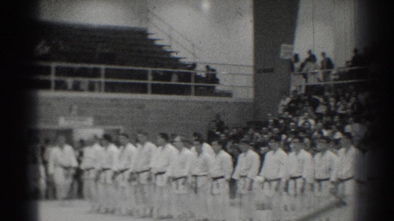 1966 San Gabriel gymnasium scene with martial artists standing in formation while spectators watch from bleachers.