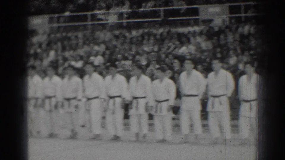 A wider 1966 San Gabriel frame shows karate participants standing shoulder to shoulder with a dense audience behind them.