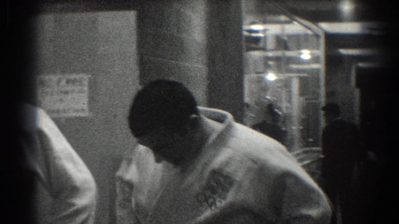 Martial artist in a white uniform bends forward in a backstage hallway.