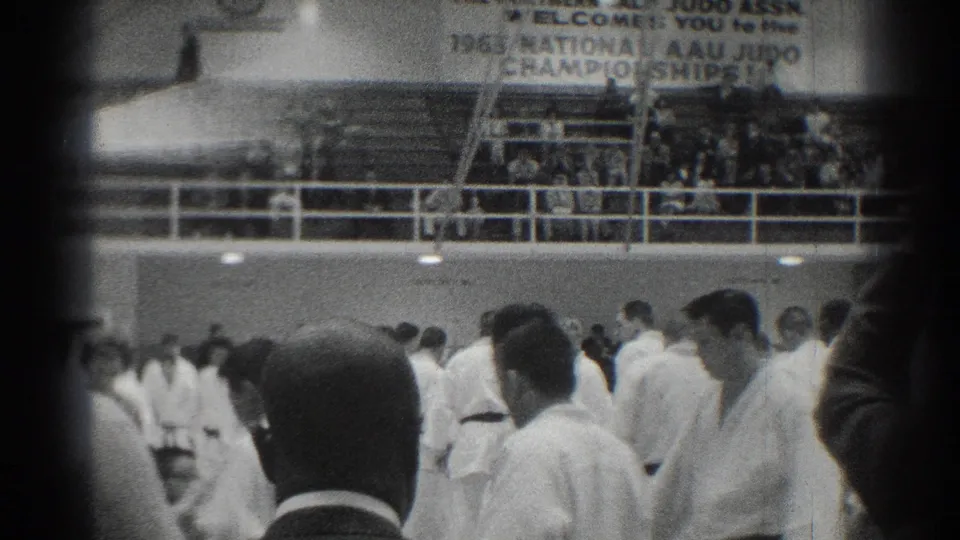 1966 National AAU Judo Championship banner appears above white-uniformed competitors and spectators inside the San Gabriel gym.