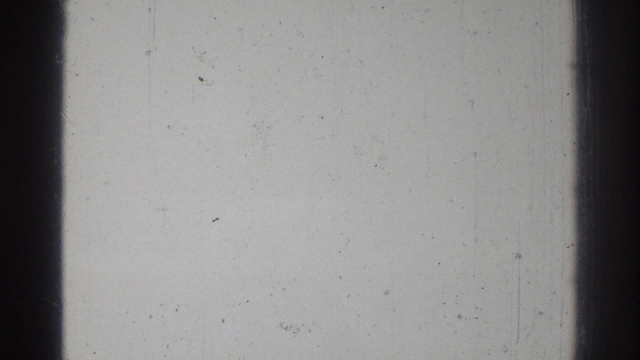 Overexposed 8mm frame from the 1966 San Gabriel home movie, dominated by pale film surface and a dark vertical frame boundary.
