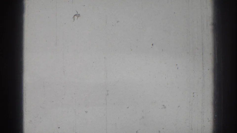 A largely blank 8mm frame from the 1966 San Gabriel clip, showing film gate edges, dust, and faint vertical wear rather than clear action.