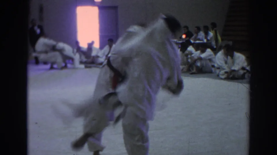 Temple City, California 1966 footage showing two gi-clad martial artists beginning a throw or grapple as others watch from the mat edge.