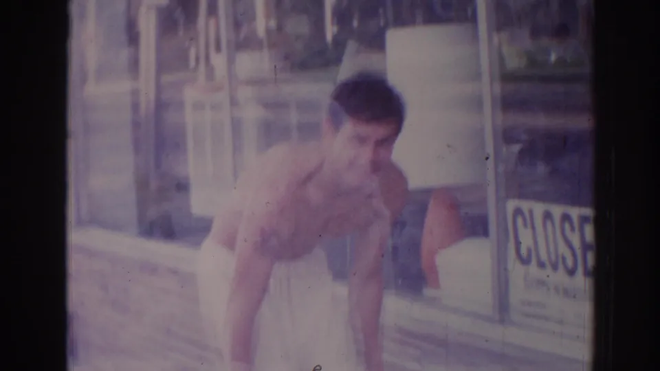 A shirtless man in a towel leans outside a Temple City storefront, with a CLOSED sign visible in the window.