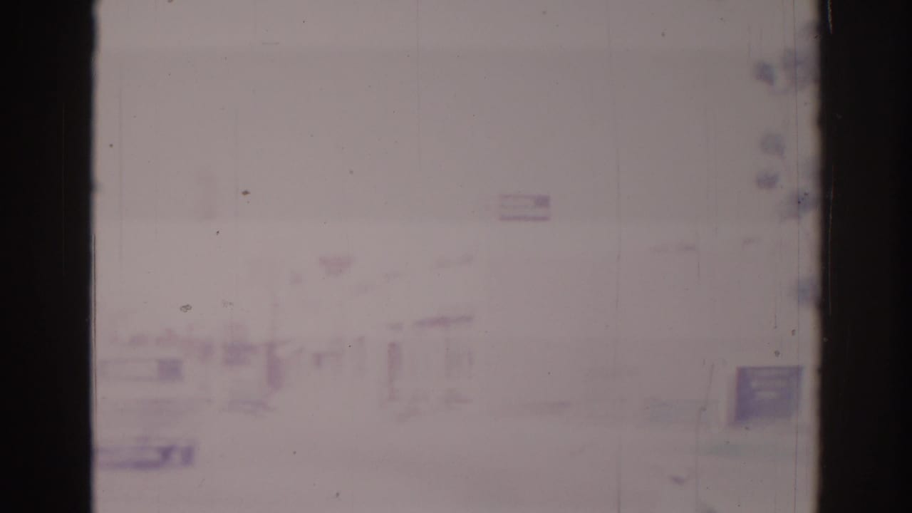 Soft, overexposed street view with low buildings and faint roadside shapes.
