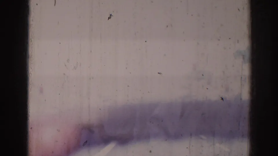 Overexposed 1966 8mm frame with visible dirt, vertical scratches, dark film borders, and a faint blurred shape near the bottom.