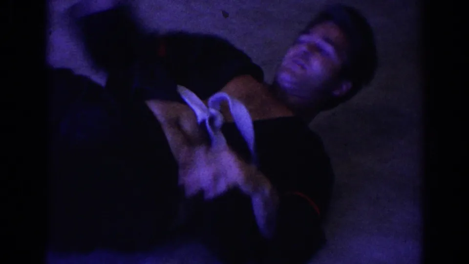 1966 Temple City frame with an adult in a dark martial arts uniform on the floor during a practice throw or roll.