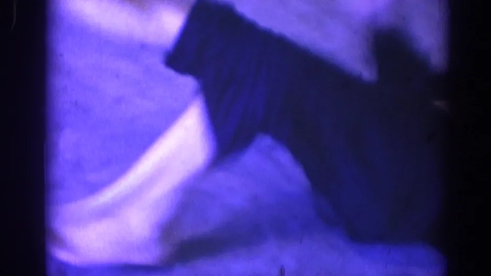 Motion-blurred 8mm frame from the martial arts practice, dominated by a white uniform moving close to the camera.