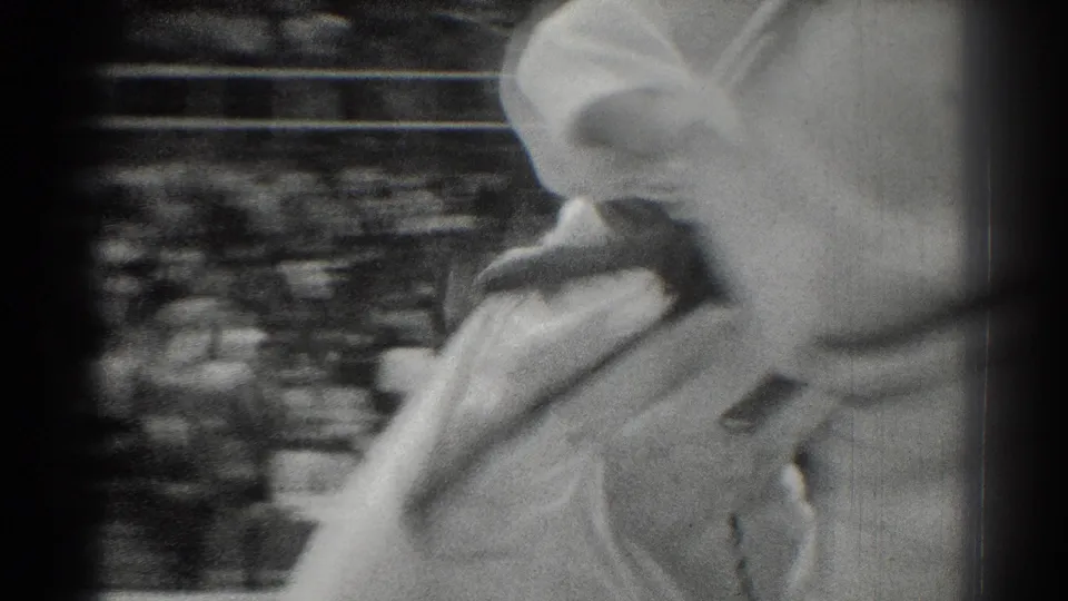 A tight, motion-blurred 8mm frame shows white-gi competitors moving quickly during the West Covina judo match.