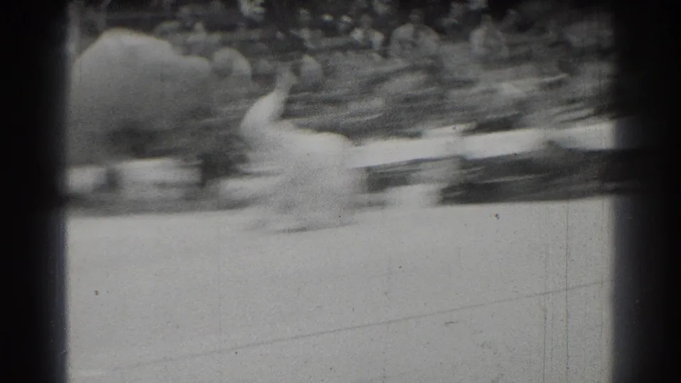 A fast judo throw or takedown blurs across the 8mm frame, with the mat and audience barely held in view.