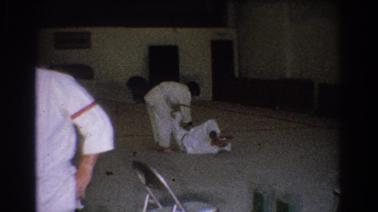 A 1966 West Covina judo training moment shows one practitioner down on the mat as another bends over during a takedown or hold.