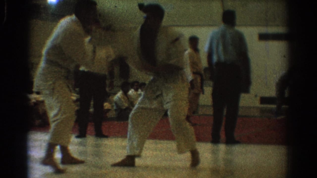 A close exchange between two uniformed martial artists is captured in soft 8mm focus inside the West Covina gymnasium.