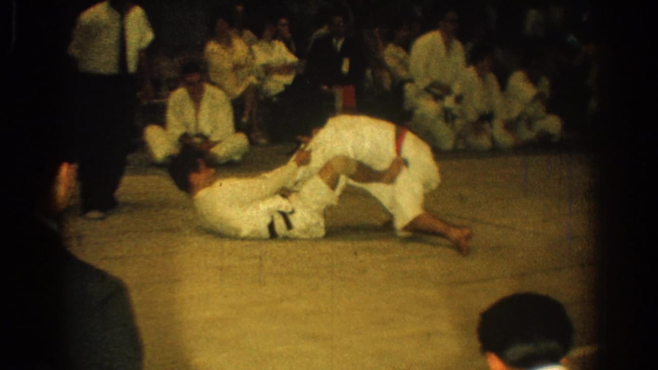 A martial arts participant in a white gi leans over an opponent on the mat during the 1966 West Covina match.