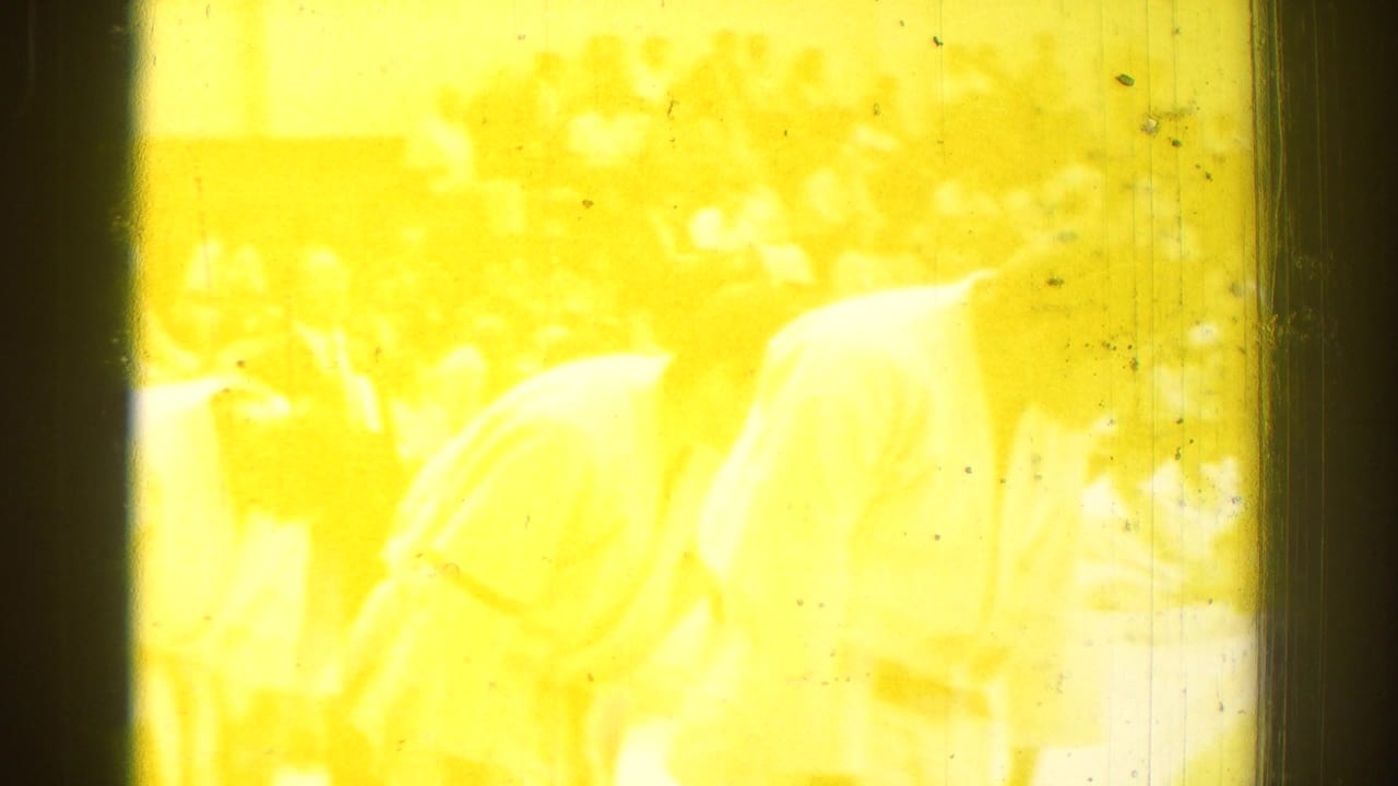 Yellow film flare and overexposure obscure much of the karate tournament scene, with faint figures still visible in the frame.