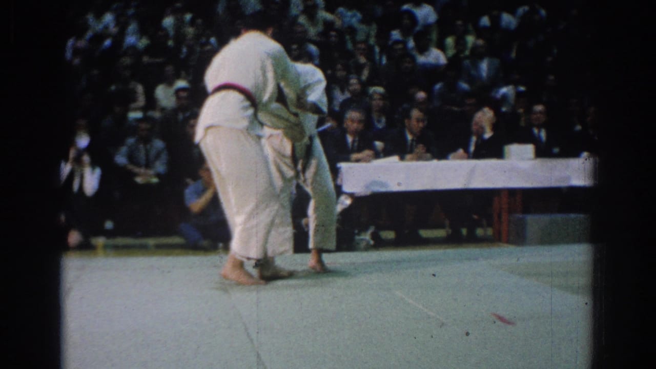 Near the end of the 1966 West Covina clip, one competitor turns his back partly toward camera as the bout continues before judges.