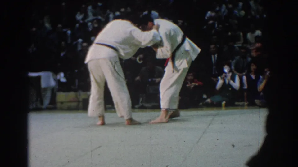 The two black-belt judokas pull in opposite directions on the West Covina mat as the audience and photographers remain close to the action.