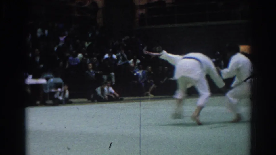 A judo throw is underway as one man bends forward and the other lifts off the mat in the West Covina demonstration.