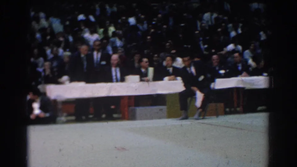 West Covina gym view showing the judges table, spectators, and partial martial arts participant at floor level.