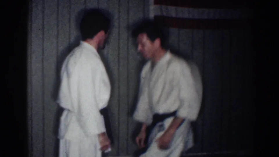 The men appear to reset between movements during a 1967 home-movie martial arts practice session in Los Angeles.