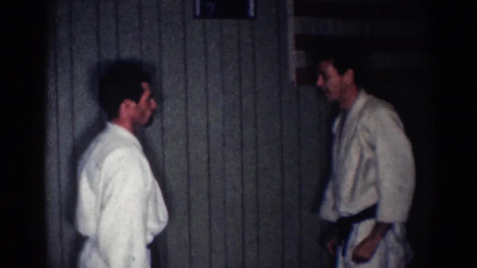 Two adult men in gi stand opposite one another during a martial arts practice sequence in 1967 Los Angeles footage.