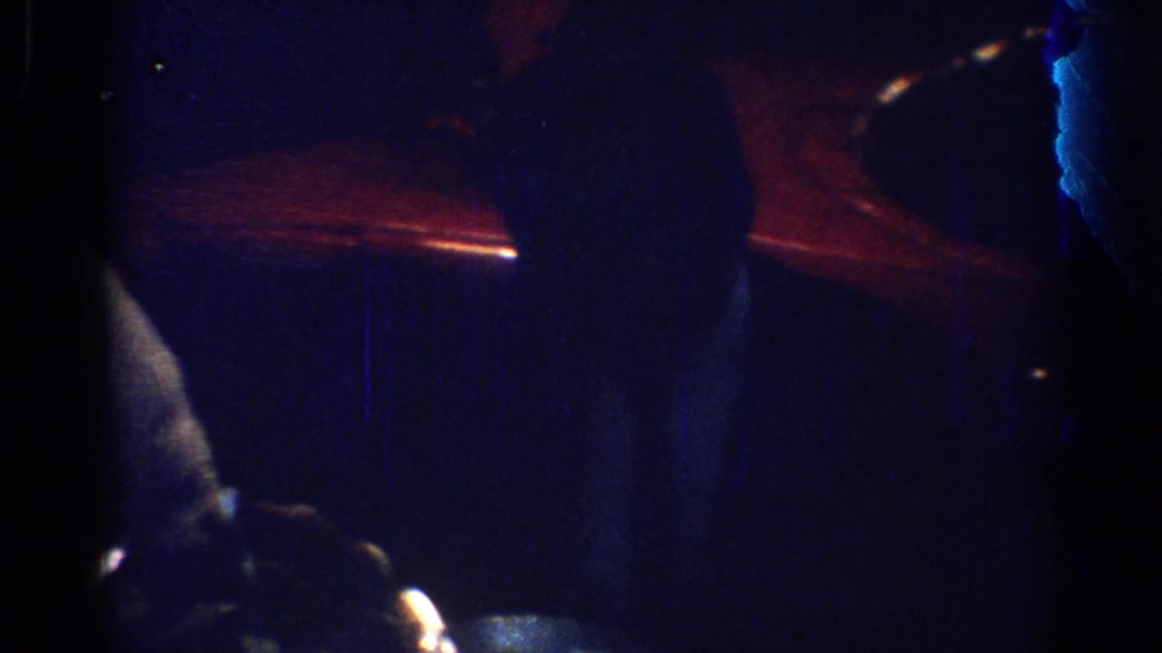 Dim dinner table with a partially visible adult and red light in the background.