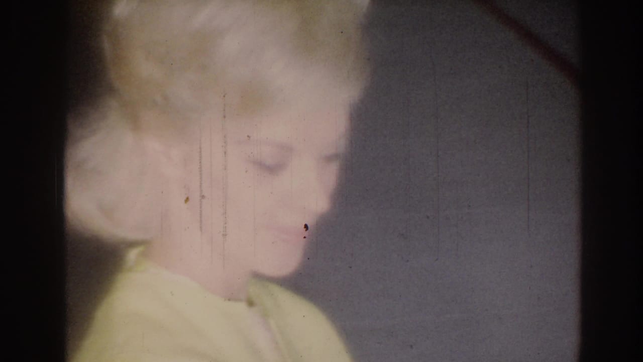 Soft 1967 home-movie frame from Los Angeles showing a blonde girl in partial profile, blurred by exposure and film wear.
