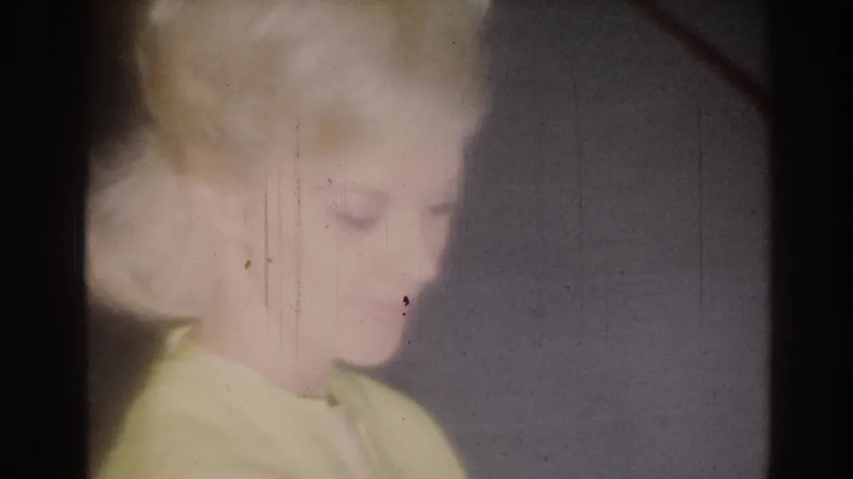 Soft 1967 home-movie frame from Los Angeles showing a blonde girl in partial profile, blurred by exposure and film wear.