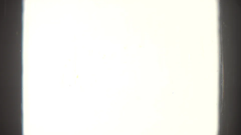 Nearly blank overexposed 8mm frame with dark side borders and slight discoloration from the 1967 home-movie source.