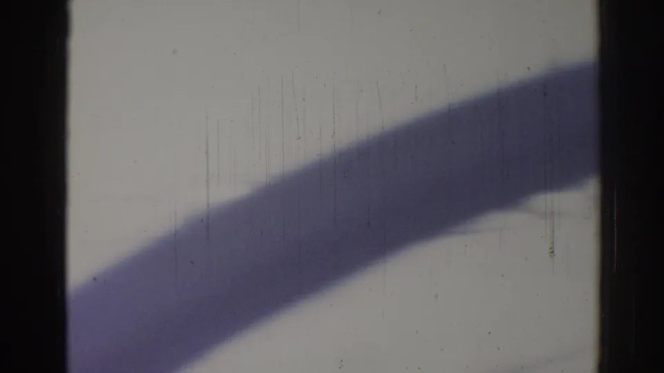 1967 Los Angeles home-movie frame with dark film edges, heavy scratches, and a broad diagonal shadow crossing the lower half.