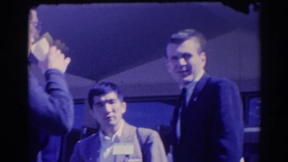 Candid 1967 Los Angeles frame of suited men with visible faces during a professional social gathering.