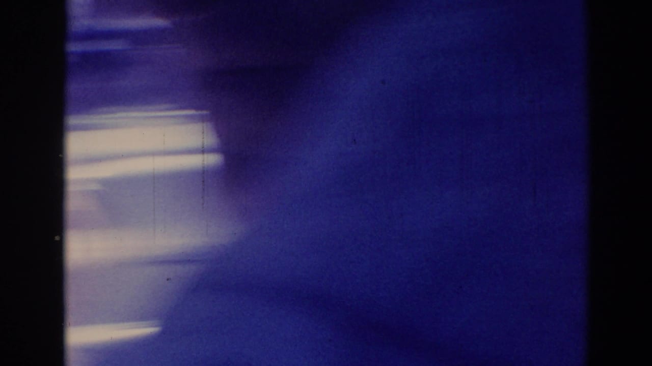 Soft blue interior view with a dark vertical window pillar and bright streaks beyond the glass.