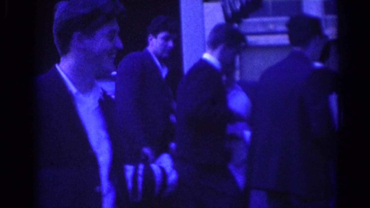 Several adult men in suits gather and talk outside a Los Angeles building in the 1967 home-movie footage.