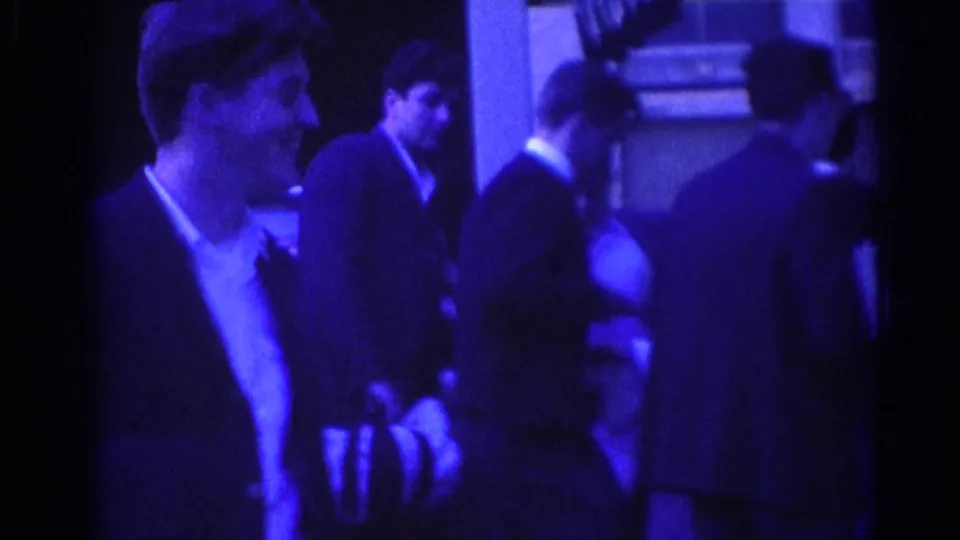 Several adult men in suits gather and talk outside a Los Angeles building in the 1967 home-movie footage.