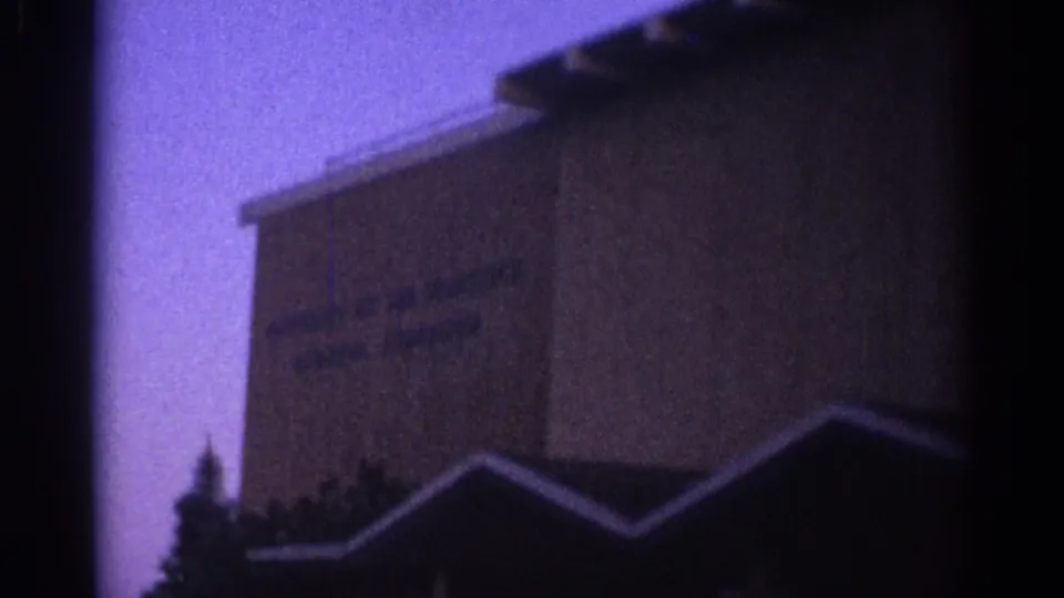 Low-angle 8mm view of a tall Los Angeles building facade, with dark rooflines crossing the lower frame.