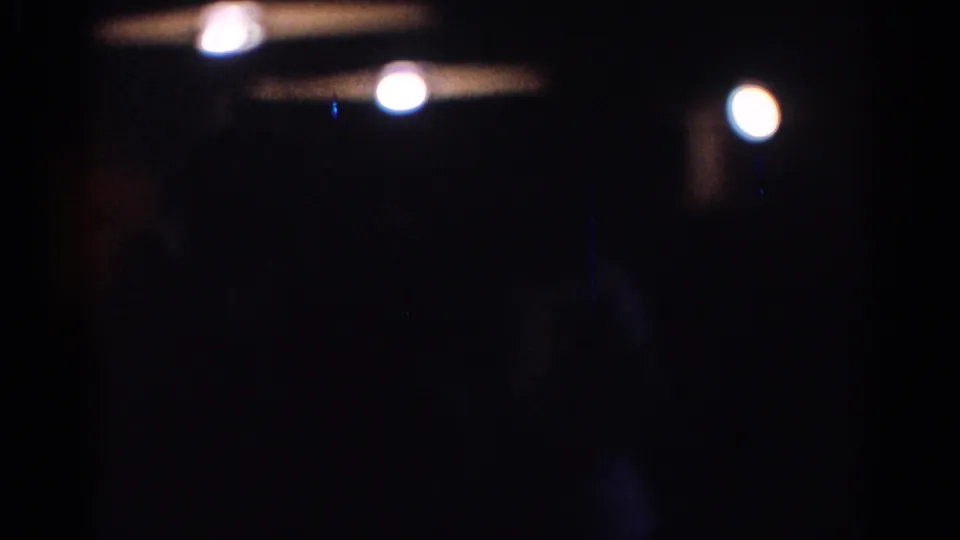 1967 Los Angeles 8mm frame with bokeh-like lights, deep underexposure, and indistinct indoor shapes.