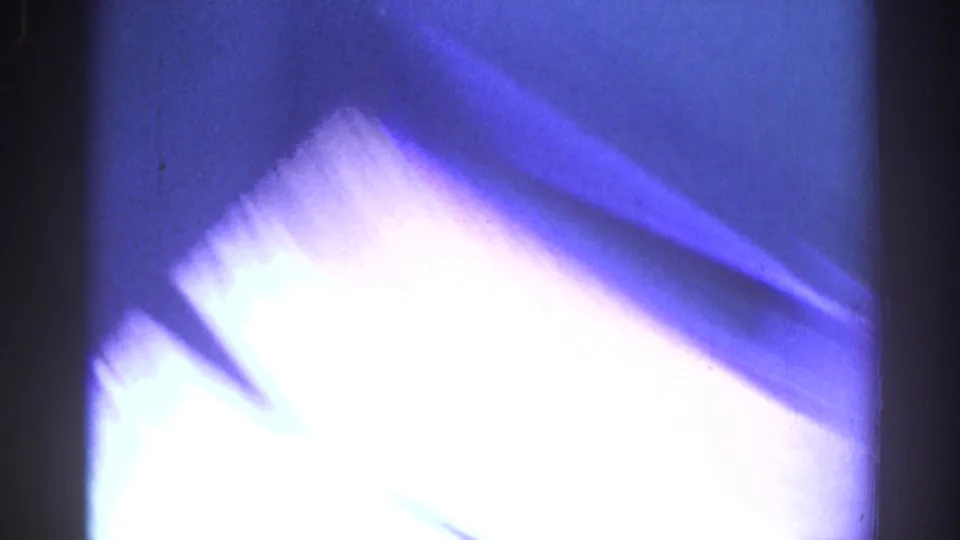 Overexposed 1967 Los Angeles 8mm frame with blue-white flare, motion blur and visible film border.