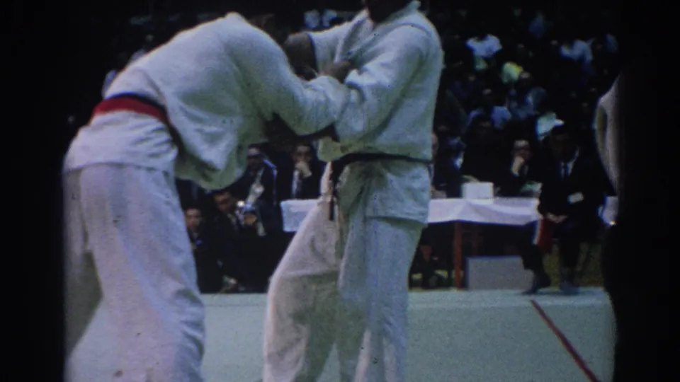 Close 8mm view of two male jiu-jitsu athletes in gi gripping each other during the Los Angeles competition.