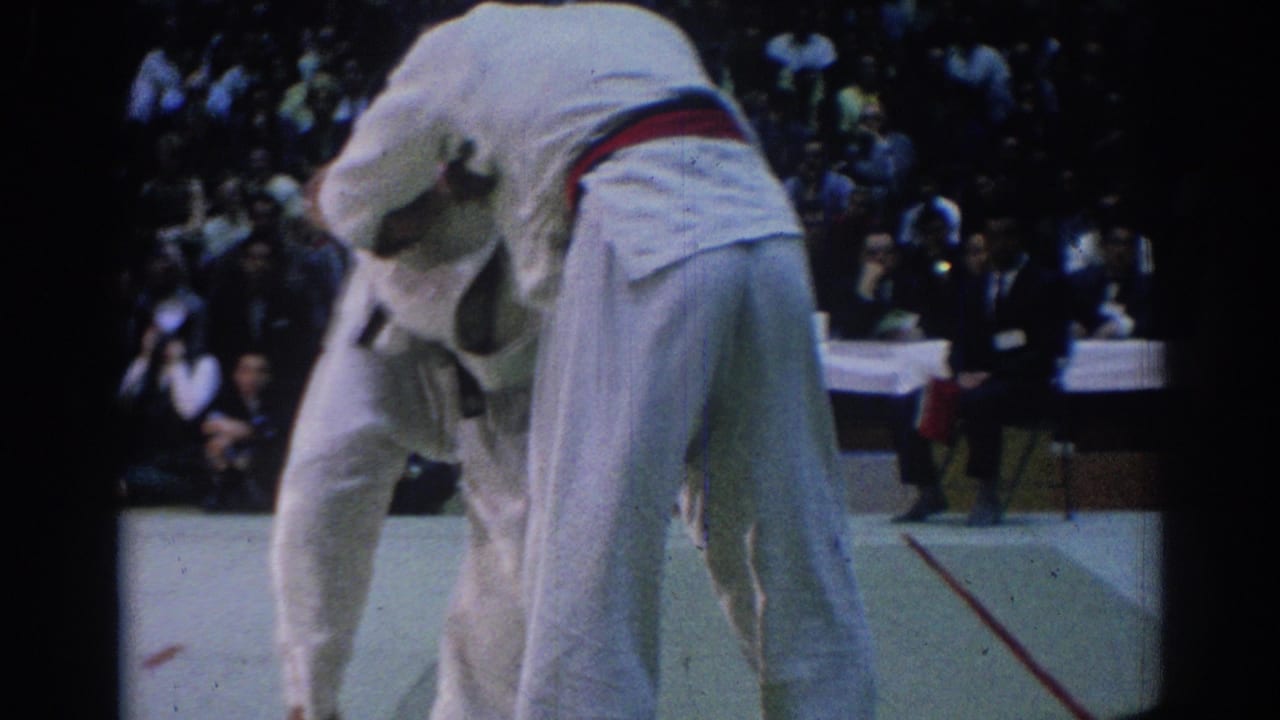 A 1967 Los Angeles judo match frame shows two competitors in white gi grappling near spectators and officials.