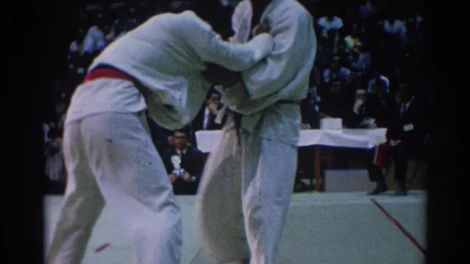 Close 8mm view from a 1967 Los Angeles judo contest, with one competitor bent into a throw or grip exchange.