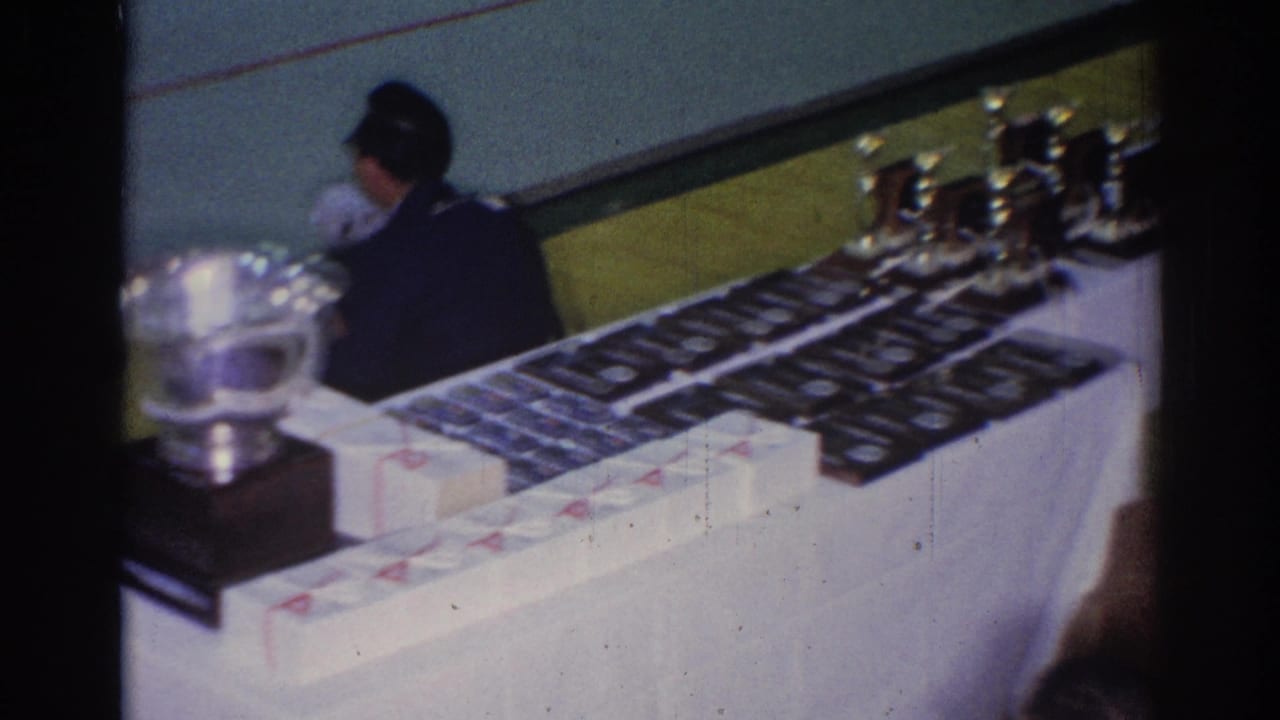 Large silver cup and rows of awards on a long table.