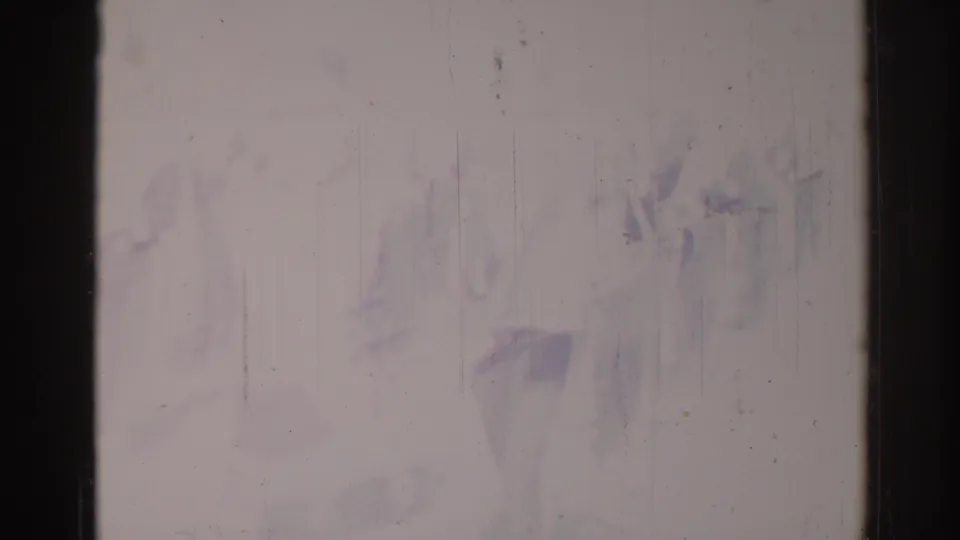 Heavily degraded 1967 Los Angeles parade footage with indistinct marching figures partly obscured by film wear.