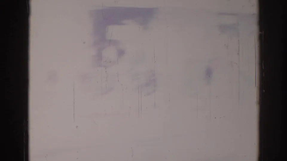 1967 Los Angeles 8mm frame showing heavy overexposure, dark gate edges, fine scratches, dust, and pale purple-blue discoloration.