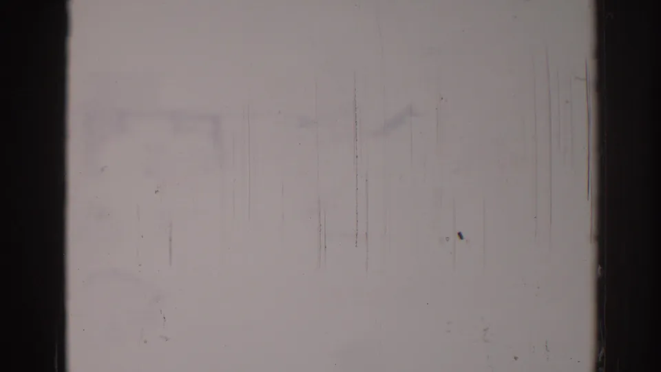 Overexposed 1967 Los Angeles home-movie frame with black film edges, vertical abrasion lines, dust, and faint bluish staining.